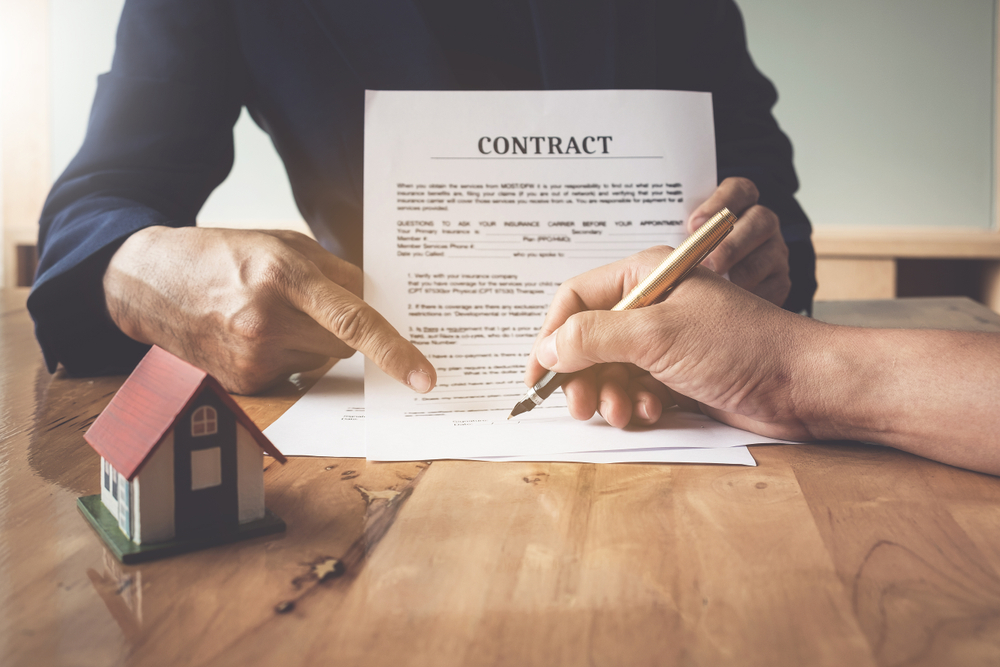 Image of Man's notary public hand pointing at the contract.