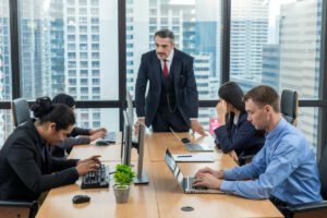 Moody boss complaining team about mistake in workplace concept.