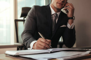 Businessman talking on mobile phone while working at his desk.